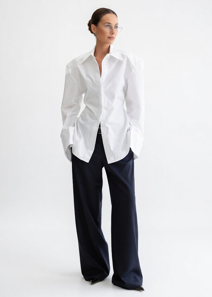 Women's white oversized cotton shirt with structured shoulders and tie waist